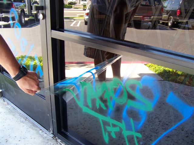 anti graffiti film being removed from window