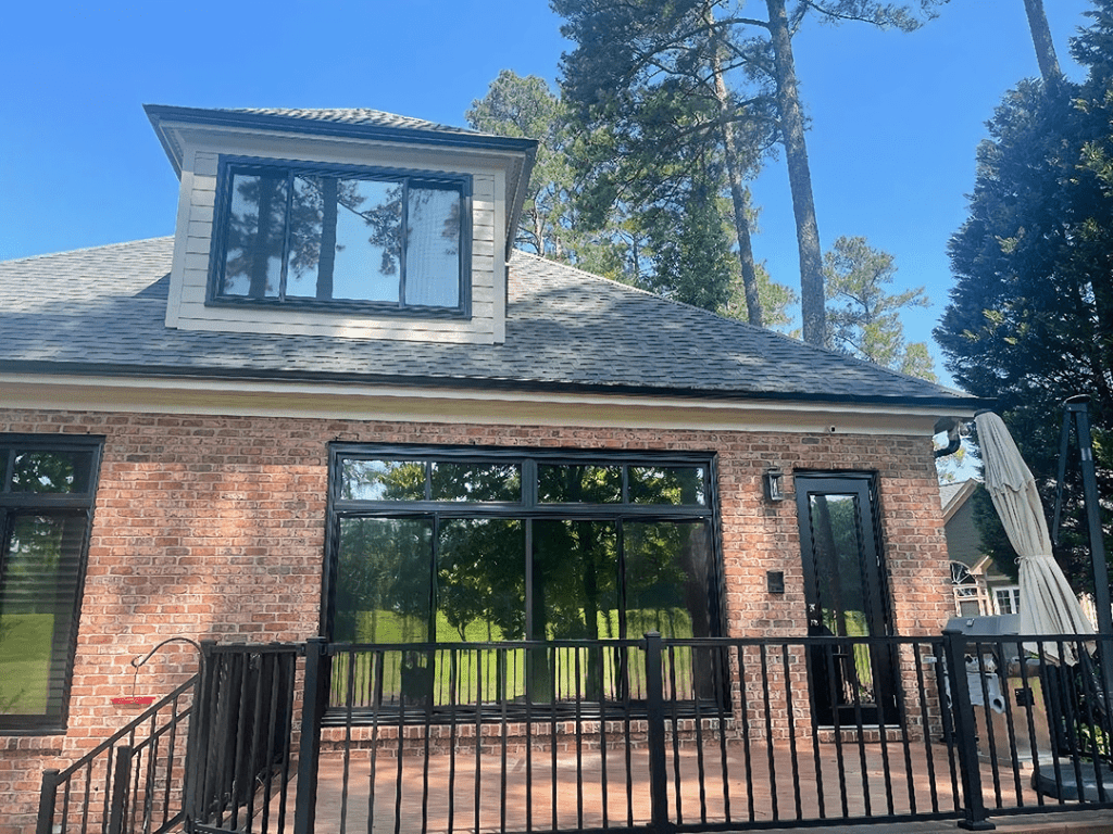 Picture of a brown brick house with tinted windows